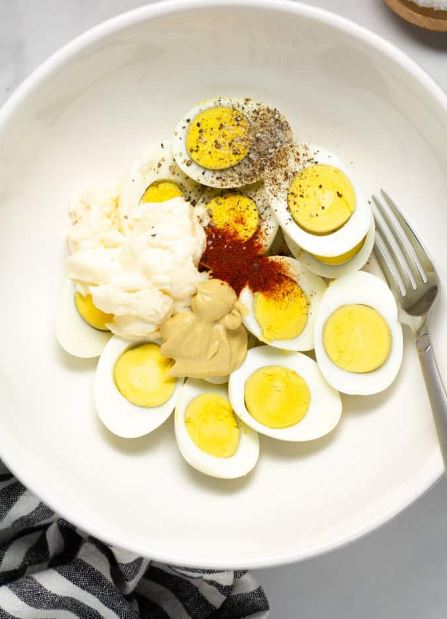 Adding mayonnaise to boiled eggs